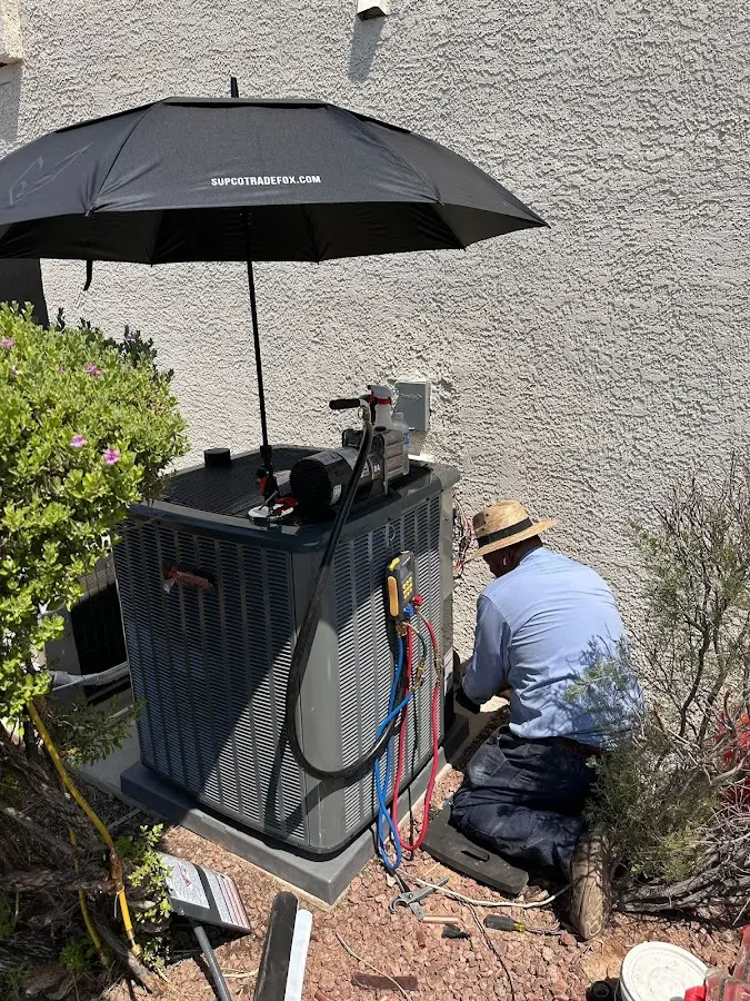 HVAC technician performing outdoor AC maintenance in Plainville